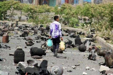 A boy walks on a street littered with cooking gas cylinders after a fire and explosions destroyed a nearby gas storage during clashes between fighters of the Popular Resistance Committees and Houthi fighters, in Yemen's southwestern city of Taiz, July 19, 2015. PHOTO BY REUTERS/Stringer