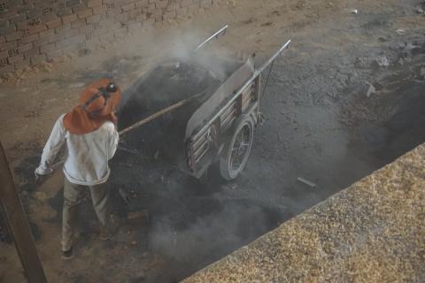 A boy shovels smoldering ash out of a kiln at a brick factory in Kandal Province, Cambodia, on January 23, 2020. PHOTO BY Thomson Reuters Foundation/Matt Blomberg