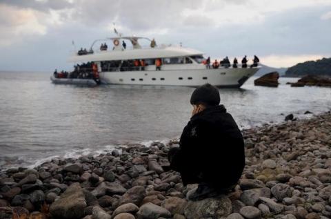 A Syrian refugee boy sits on a beach after disembarking from a luxury yacht used by about 250 other Syrian refugees and to travel across the Aegean Sea from the Turkish coast in the Greek island of Lesbos, November 21, 2015. PHOTO BY REUTERS/Yannis Behrakis