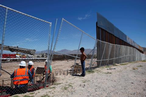A boy looks at U.S. workers building a section of the U.S.-Mexico border wall at Sunland Park, U.S. opposite the Mexican border city of Ciudad Juarez, Mexico. PHOTO BY REUTERS/Jose Luis Gonzalez