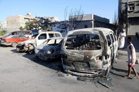 A boy looks at damaged vehicles following heavy clashes between rival factions in Abu Salim district in Tripoli, Libya, May 28, 2017. PHOTO BY REUTERS/Hani Amara