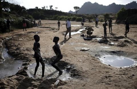 Karamojong tribe boys bath in a dry riverbed in town of Kaabong in Karamoja region, Uganda, February 17, 2016. PHOTO BY REUTERS/Goran Tomasevic