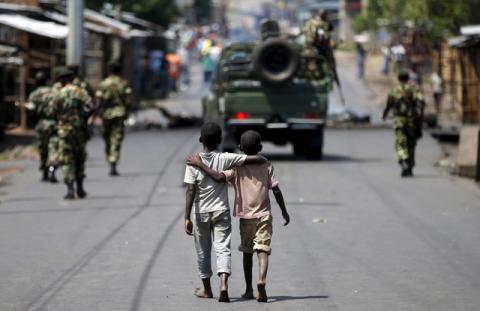 Boys walk behind patrolling soldiers in Bujumbura, Burundi, May 15, 2015. PHOTO BY REUTERS/Goran Tomasevic