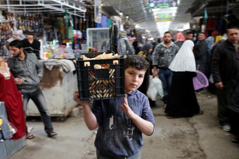 An Iraqi boy carry bread at A Nabey Yunes market in the city of Mosul, Iraq, March 19, 2017. PHOTO BY REUTERS/Youssef Boudlal