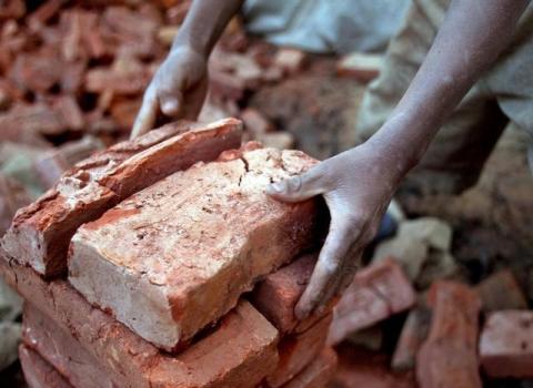 A Nepali boy carrying a stack of bricks at a brick factory in Bhaktapur, Nepal, March 28, 2005. PHOTO BY REUTERS/Nicky Loh