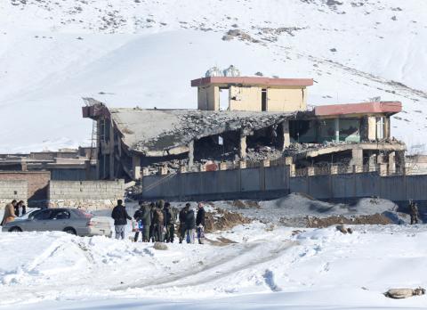 Afghan men stand in front of a collapsed building of a military base after a car bomb attack in Maidan Wardak, Afghanistan, January 21, 2019. PHOTO BY REUTERS/Stringer