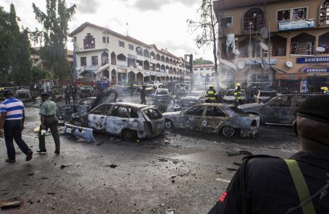 Burnt-out cars are seen at the scene of a blast in Abuja, Nigeria