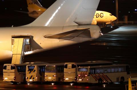 Buses believed to carry the U.S. passengers of the cruise ship Diamond Princess, where dozens of passengers were tested positive for coronavirus, are parked next to an airplane in Yokohama, south of Tokyo, Japan, February 17, 2020. PHOTO BY REUTERS/Issei Kato