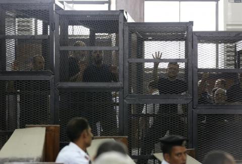 Muslim Brotherhood's General Guide Mohamed Badie (R) is pictured in a defendant's cage with other defendants in a courtroom in Cairo