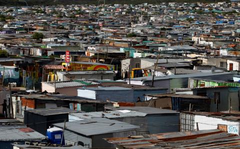 Residents walk through shacks in Cape Town's crime-ridden Khayelitsha township in this picture taken July 9, 2012. PHOTO BY REUTERS