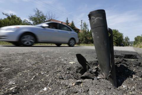 A car drives past the remains of a spent ammunition on the suburbs of Donetsk