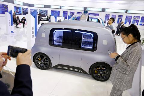 A visitor takes a picture of a Neolix self-driving vehicle at the IEEV New Energy Vehicles Exhibition in Beijing, China October 18, 2018. REUTERS/Thomas Peter