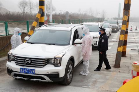 Medical workers in protective suits check the body temperature of car passengers at a checkpoint outside the city of Yueyang, Hunan Province, near the border to Hubei Province that is on lockdown after an outbreak of a new coronavirus, China, January 28, 2020. PHOTO BY REUTERS/Thomas Peter