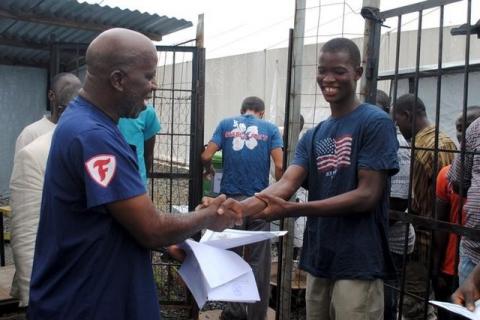 Cassius Kollie (R), 24, one of four people discharged from an Ebola treatment unit, receives a certificate for being cured of the disease in Paynesville, Liberia, July 20, 2015. PHOTO BY REUTERS/James Giahyue