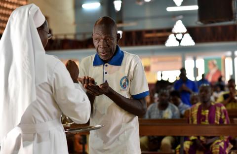 A catholic man receives communion at the cathedral of Our Lady of Kaya in the city of Kaya, Burkina Faso, May 16, 2019. PHOTO BY REUTERS/Anne Mimault