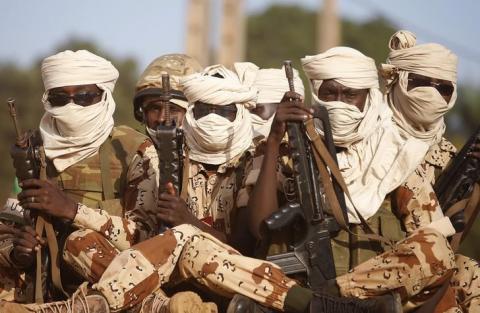 Chadian soldiers sit with guns on a vehicle as they drive in Bangui April 4, 2014. PHOTO BY REUTERS/Goran Tomasevic