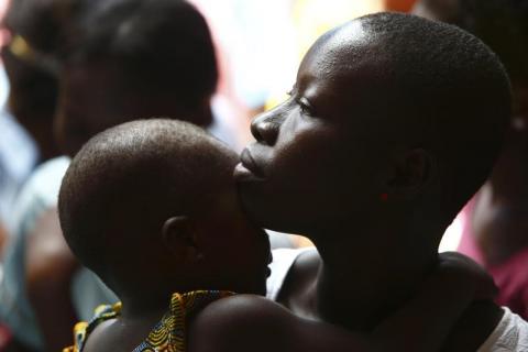 A woman and her child attend a talk on sexual and domestic violence and HIV/AIDS prevention organised by the local chamber of professional workers and the Centre Esperance Loyola (CEL - Loyola Hope Centre), a West African Jesuit organisation, in Agoe-Nyive, a suburb of Lome, April 15, 2013. PHOTO BY REUTERS/Darrin Zammit Lupi