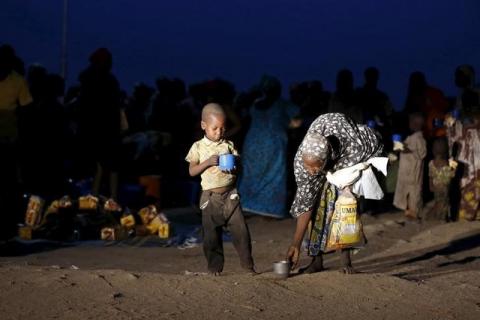 A child and mother rescued from Boko Haram in Sambisa forest by Nigeria Military pick up their food after arriving at the Internally displaced people's camp in Yola, Adamawa State, Nigeria, May 2, 2015. PHOTO BY REUTERS/Afolabi Sotunde