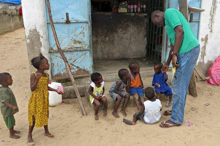 Mamadou Ka greets children near his family home after being repatriated last month from Gabon, in Dakar, Senegal, September 2, 2015. PHOTO BY REUTERS/Makini Brice