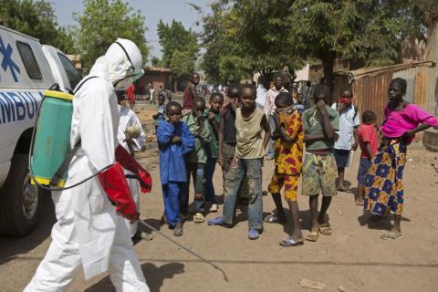 Children watch as a health worker sprays disinfectants outside a mosque in Bamako, November 14, 2014. PHOTO BY REUTERS/Joe Penney