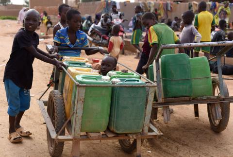 Displaced children that fled from their villages in northern Burkina Faso, following attacks by assailants, push carts loaded with water containers at a school on the outskirts of Ouagadougou, Burkina Faso, June 15, 2019. PHOTO BY REUTERS/Anne Mimault