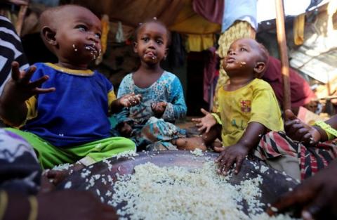 Internally displaced Somali children eat boiled rice outside their family's makeshift shelter at the Al-cadaala camp in Somalia's capital Mogadishu, March 6, 2017. PHOTO BY REUTERS/Feisal Omar