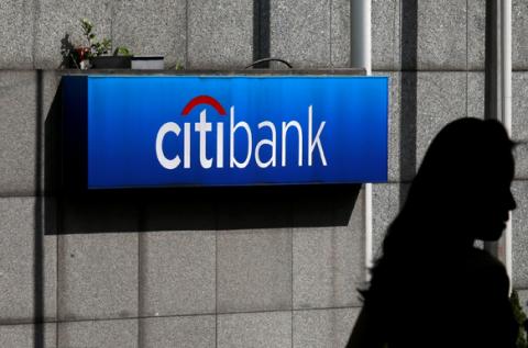 A woman walks past a Citibank logo displayed outside the Citibank Plaza in Hong Kong, July 28, 2014. PHOTO BY REUTERS/Bobby Yip