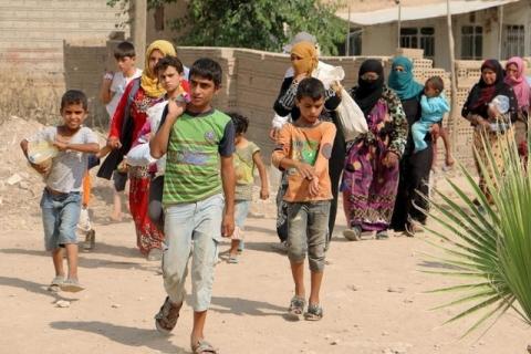 Civilians, who fled the violence in Hasaka city, carry their belongings as they arrive to Amouda town, east of Qamishli in Hasaka governorate, Syria, June 27, 2015. PHOTO BY REUTERS/Rodi Said