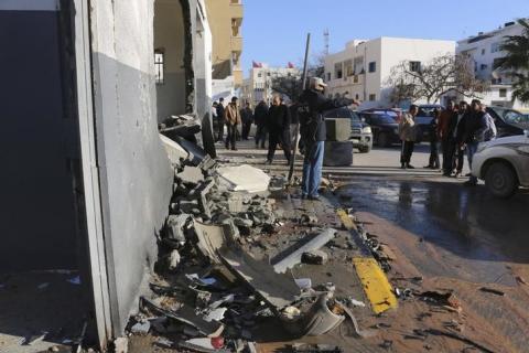 Civilians and security personnel stand at the scene of an explosion at a police station in the Libyan capital Tripoli, March 12, 2015. PHOTO BY REUTERS/Hani Amara