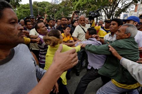 Pro-government supporters clash with opposition supporters during a protest against Venezuelan President Nicolas Maduro's government outside the Venezuelan Prosecutor's office in Caracas, Venezuela, March 31, 2017. PHOTO BY REUTERS/Marco Bello