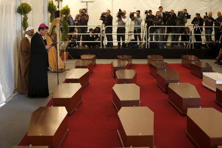 Bishop of the Maltese island of Gozo, Mario Grech (2nd L) and Imam Mohammed El Sadi (far L) deliver messages in front of the coffins with the bodies of 24 migrants during an inter-faith burial service at Mater Dei Hospital in Tal-Qroqq, outside Valletta, April 23, 2015. PHOTO BY REUTERS/Darrin Zammit Lupi