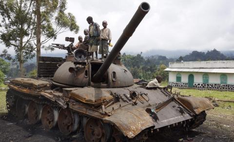 Congolese children play on a destroyed military tank, abandoned by the M23 rebel fighters who surrendered in Kibumba