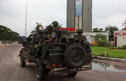 Congolese soldiers ride on their pick-up truck towards the state television headquarters in the capital Kinshasa