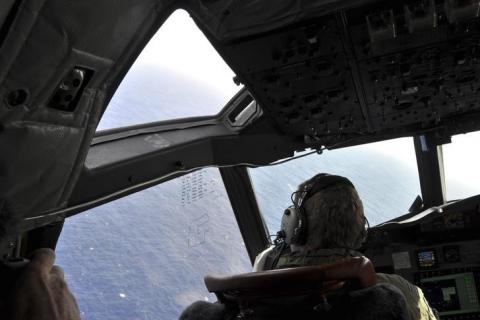 A crew member sits in the cockpit of a Royal New Zealand Air Force (RNZAF) AP-3C Orion maritime patrol aircraft as it continues searching in the southern Indian Ocean for the missing Malaysian Airlines flight MH370