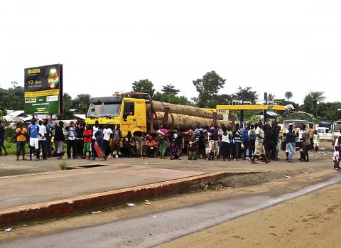 A crowd gathers near a checkpoint, which controls the movement of people in and out of Ebola-hit regions, at the entrance to Bomi county in northwestern Liberia