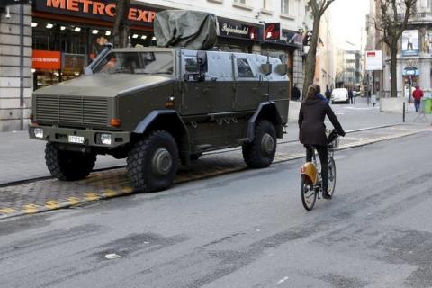 A cyclist rides past a military armoured vehicle in central Brussels, December 31, 2015. PHOTO BY REUTERS/Francois Lenoir