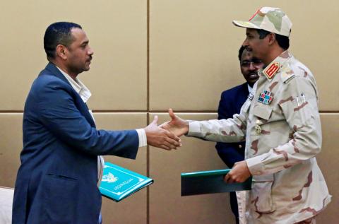 Deputy Head of Sudanese Transitional Military Council, Mohamed Hamdan Dagalo shakes hands with Sudan's opposition alliance coalition's leader Ahmad al-Rabiah as they exchange signed copies of the constitutional declaration during a signing ceremony in Khartoum, Sudan, August 4, 2019. PHOTO BY REUTERS/Mohamed Nureldin Abdallah