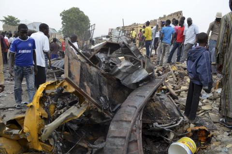 People look at damage in a market area after a bomb explosion in Ajilari-Gomari near the city's airport, Maiduguri, Borno State