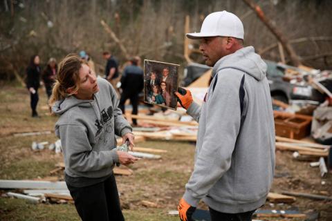 Dax Leandro shows Julie Morrison (not pictured) a family photo he found in the wreckage of her home after two back-to-back tornadoes touched down, in Beauregard, Alabama, U.S., March 4, 2019. PHOTO BY REUTERS/Elijah Nouvelage