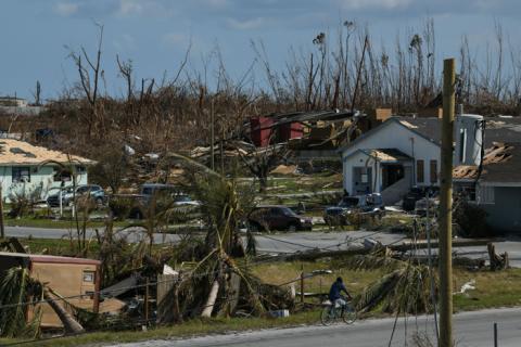 A man rides a bicycle past damage in the wake of Hurricane Dorian in Marsh Harbour, Great Abaco, Bahamas, September 7, 2019. PHOTO BY REUTERS/Loren Elliott