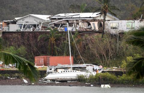 A damaged building is seen behind a boat that was pushed onto a bank due to Cyclone Debbie in the township of Airlie Beach, located south of the northern Australian city of Townsville, March 29, 2017. PHOTO BY REUTERS/AAP/Dan Peled