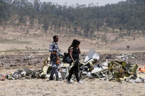 A Kenyan woman looks at debris of the Ethiopian Airlines Flight ET 302 plane crash after a commemoration ceremony at the scene of the crash, near the town of Bishoftu, southeast of Addis Ababa, Ethiopia, March 13, 2019. PHOTO BY REUTERS/Baz Ratner