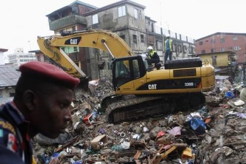 Rescuers operate an excavator at the site of a collapsed building, earlier marked for demolition, in Ebutte-Meta district in Lagos, July 11, 2013. PHOTO BY REUTERS/Akintunde Akinleye