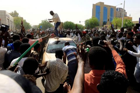 Sudanese demonstrators block the vehicle of a military officer as they chant slogans as they protest against the army's announcement that President Omar al-Bashir would be replaced by a military-led transitional council, in Khartoum, Sudan, April 11, 2019. PHOTO BY REUTERS/Stringer