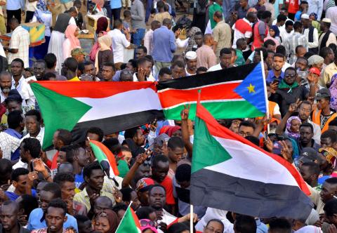 Sudanese demonstrators display their national flag and the national flag of South Sudan, as they attend a sit-in protest outside the Defence Ministry in Khartoum, Sudan, April 14, 2019. PHOTO BY REUTERS/Stringer