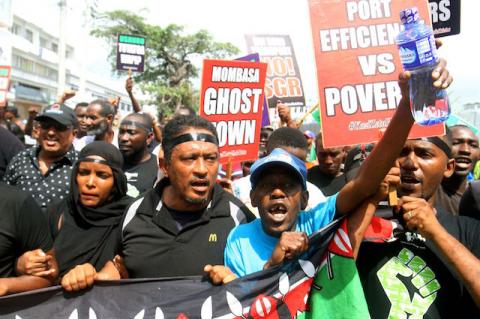 Demonstrators hold signs against the Kenyan government, which plans to allow transport of goods from the Mombasa port only by railway, during a protest in Mombasa, Kenya, September 30, 2019. PHOTO BY REUTERS/Joseph Okanga