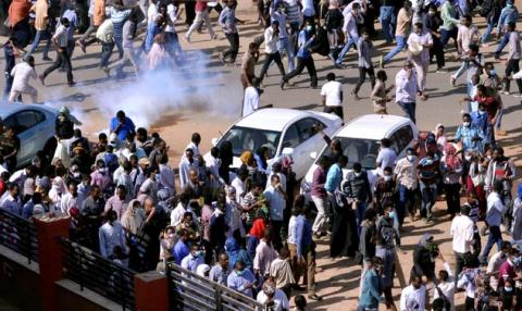 Sudanese demonstrators run from teargas lobbed to disperse them as they march along the street during anti-government protests in Khartoum, Sudan, December 25, 2018. PHOTO BY REUTERS/Mohamed Nureldin Abdallah