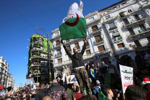 A demonstrator carries a national flag during protest over President Abdelaziz Bouteflika's decision to postpone elections and extend his fourth term in office, in Algiers, Algeria, March 15, 2019. PHOTO BY REUTERS/Ramzi Boudina