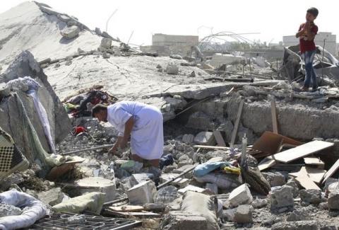 A man looks through the debris of a destroyed building after a Syrian war plane crashed in Raqqa, in northeast Syria, September 16, 2014. PHOTO BY REUTERS/Stringer