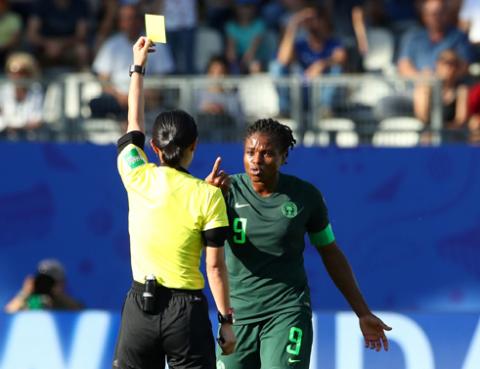 Nigeria's Desire Oparanozie is shown a yellow card by referee Yoshimi Yamashita. PHOTO BY REUTERS/Denis Balibouse